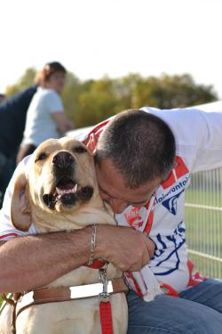 Un homme prends un labrador dans ses bras