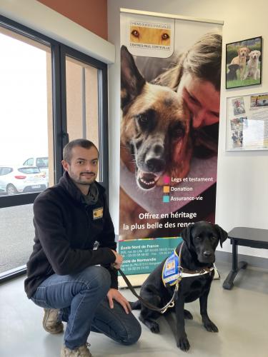 Antoine Magniez, éducateur pose avec Osan, un élève chien guide d'aveugle