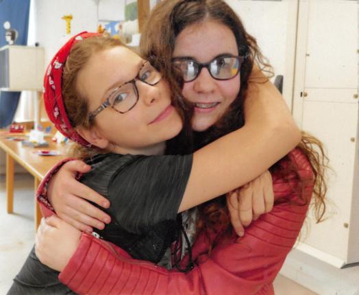 Romane, jeune adolescente ayant un handicap visuel et maîtresse de chien guide d'aveugle, pose avec Elona, sa meilleure amie