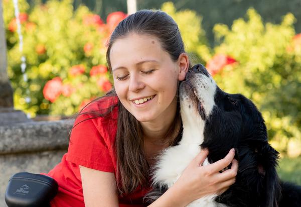 une adolescente déficiente visuelle fait un calin a son chien guide 