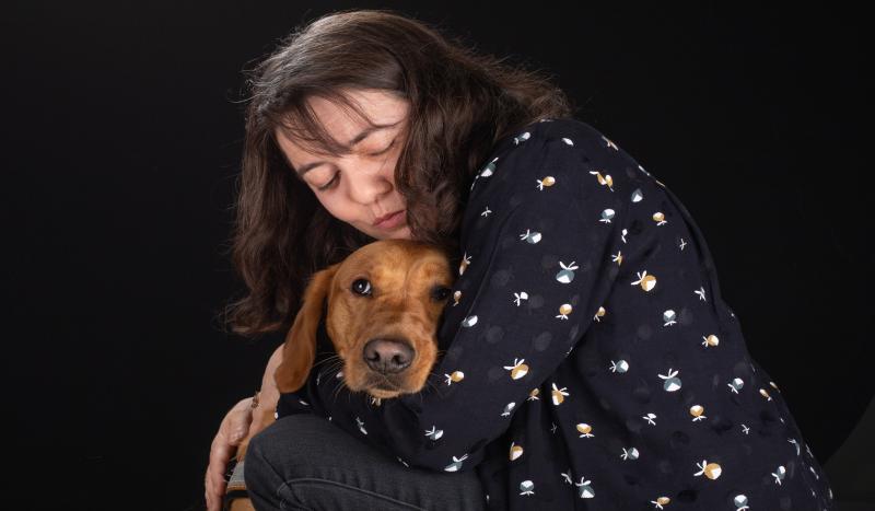 une femme fait un calin à son chien guide d'aveugle