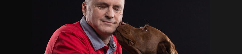 Un homme pose tête contre tête avec son chien d'aveugle